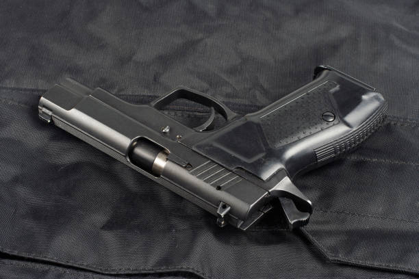 istock Police concept - handgun on black uniform background 917056464