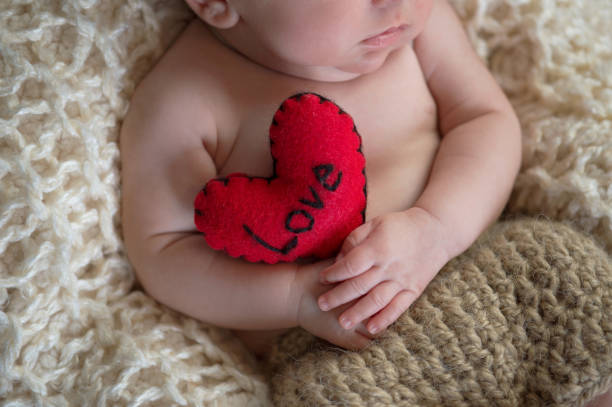 Baby Holding a Heart Shaped Pillow stock photo