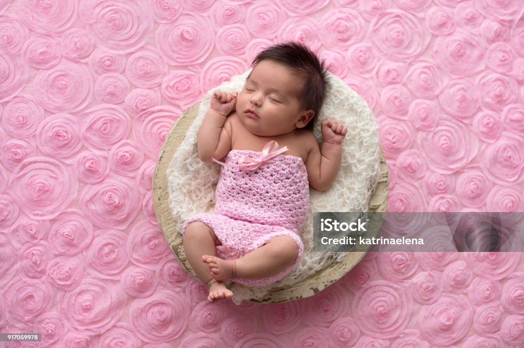 Bébé fille qui porte une salopette rose, au crochet - Photo de Bébé libre de droits