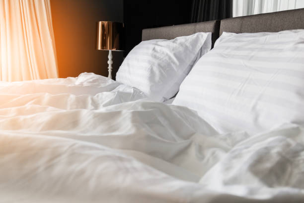 istock unmade rumpled bed with white messy pillows  in bedroom interior morning light 917073580