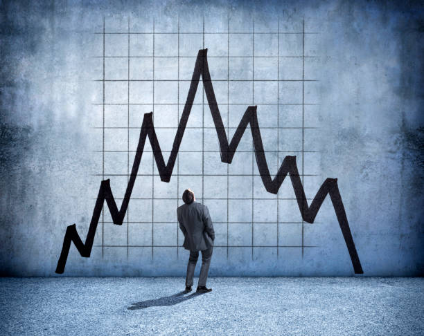istock Businessman Stands And Looks Up At A Falling Arrow 917075954