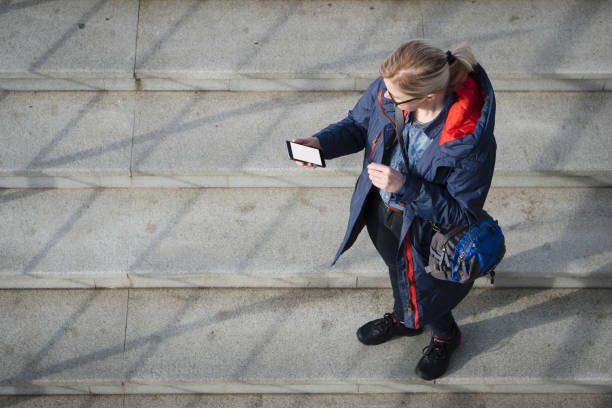 istock Top view of a woman is using smart phone while is standing on background with copy space. 917079412