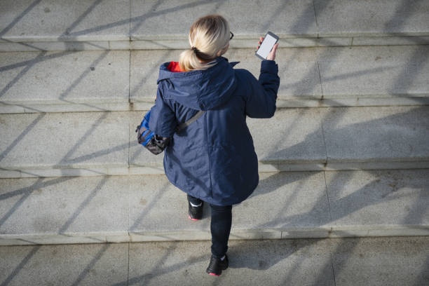 istock Top view of a woman is using smart phone while is standing on background with copy space. 917079452