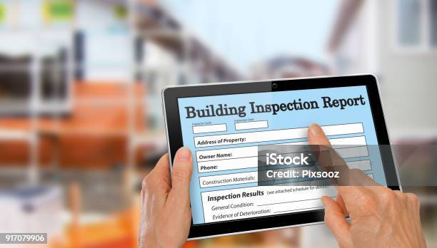 Buiding Inspector Completing An Inspection Form On Computer Tablet Stock Photo - Download Image Now