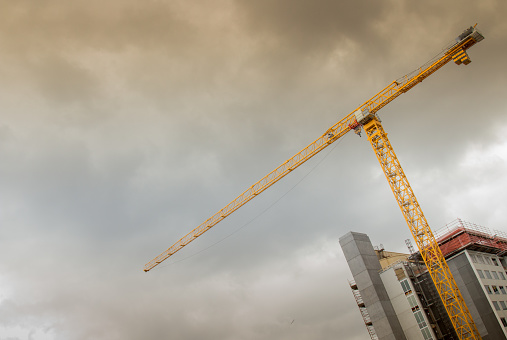 Single crane at a building development with storm clouds in the background