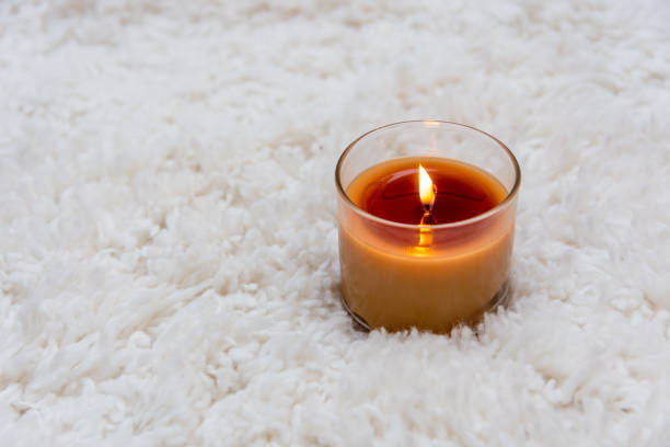 istock Orange candle burning on white textured background with room for copy 917091078
