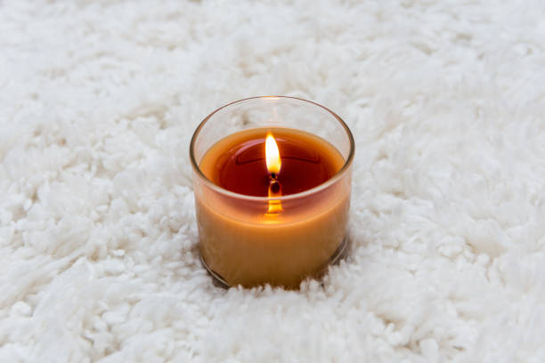 istock Orange candle burning on white textured background with room for copy 917091084