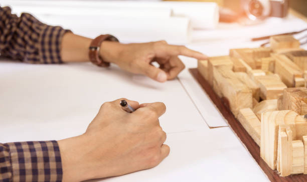 istock Concept architects,engineer holding pen pointing equipment architects On the desk with a blueprint in the office, Vintage, Sunset light.Selective Focus 917091214