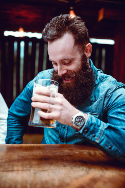 istock Handsome Bearded Hipster Person Drinking Beer In Pub and Enjoying 917093630