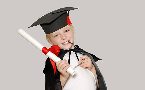 schoolboy in graduation cap isolated stock photo