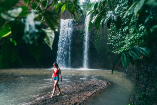 mulher andando perto tibumana cachoeira em bali, indonésia - chearful - fotografias e filmes do acervo