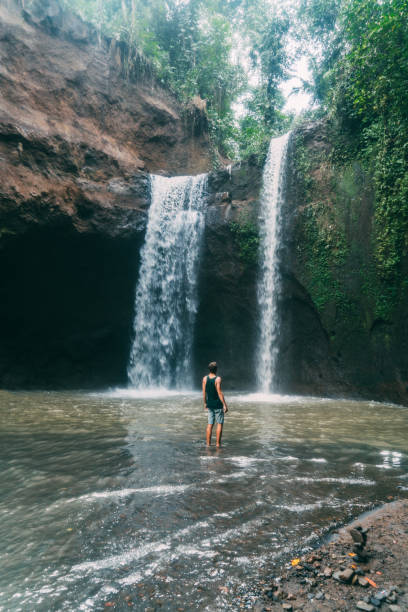 istock Man walking near  Tegenungan waterfall in Bali 917104358