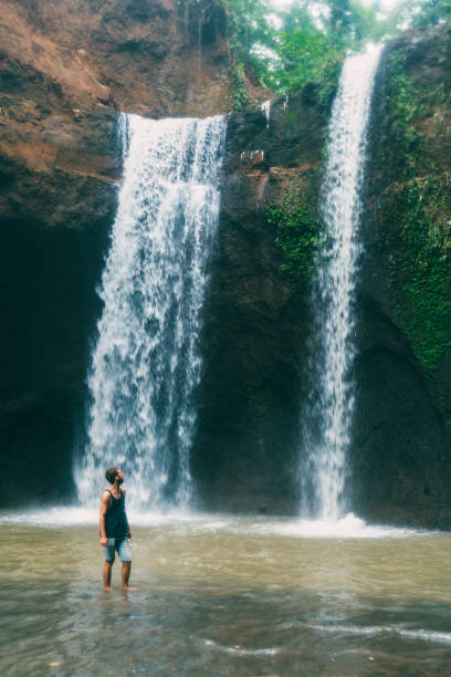 istock Man walking near  Tegenungan waterfall in Bali 917104410