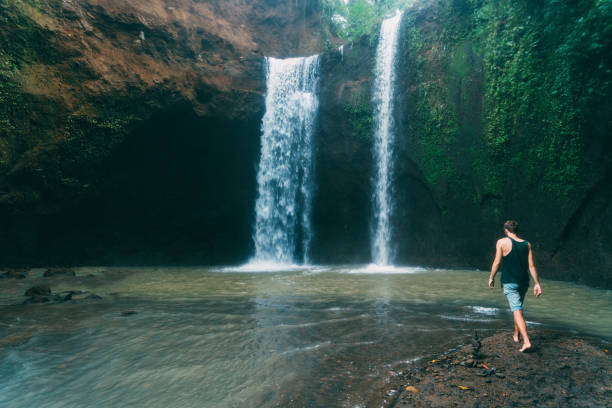 istock Man walking near  Tegenungan waterfall in Bali 917104432