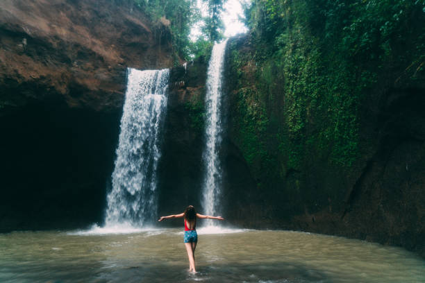 mulher andando perto tibumana cachoeira em bali, indonésia - chearful - fotografias e filmes do acervo