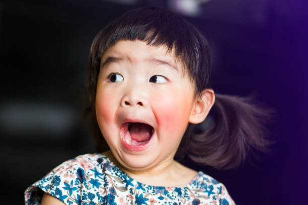 A little lovely asian girl feels shocked and open mouth wide stock photo
