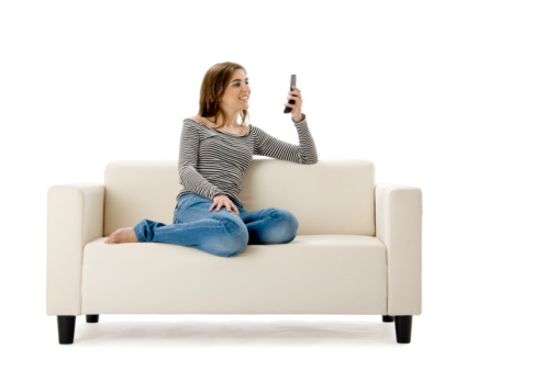 Beautiful woman on a white sofa making a phone call