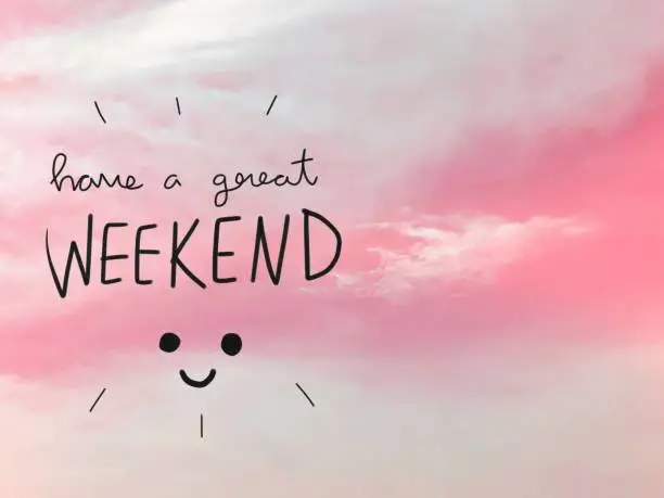 Have a great weekend word and smile face on pink sky background