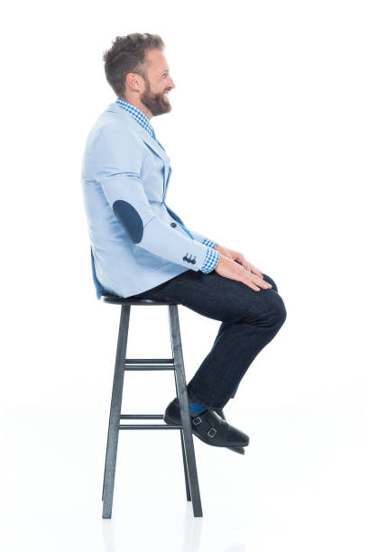 istock Handsome businessman seated on stool 917125714