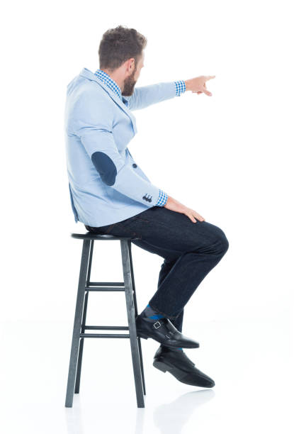 istock Handsome businessman seated on stool 917125760