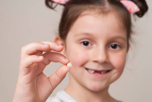 istock little girl holding a milk tooth 917126272