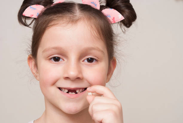 istock little girl holding a milk tooth 917126284
