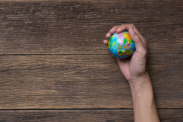 Earth planet in female hand on wood table