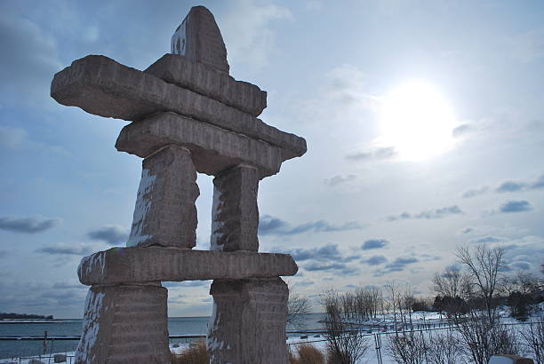 A beautiful sunset and an inukshuk in the Arctic frame a woman hiker.  Click to view similar images.