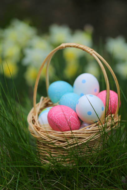 istock Easter .basket with Easter blue and pink eggs in green grass on blurred floral background. Easter mood 917132600