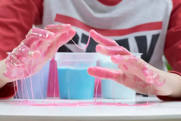 Hand Holding Homemade Plaything Called Slime, Teenager having fun and being creative homemade Toy, Selective focus on Slime.