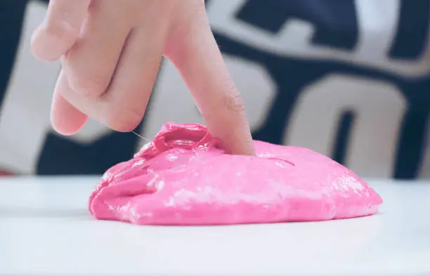 Hand Holding Homemade Plaything Called Slime, Teenager having fun and being creative homemade Toy, Selective focus on Slime.