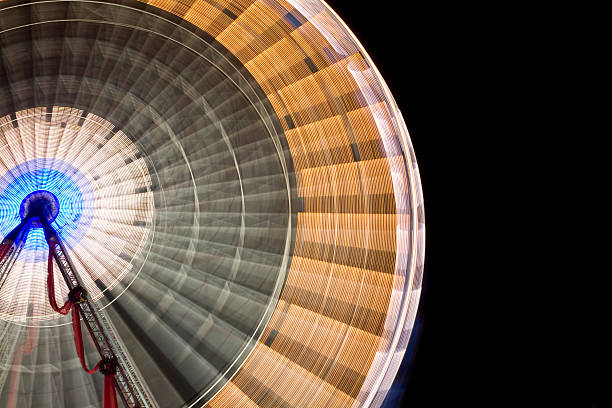 Spinning ferris wheel at night against black sky stock photo