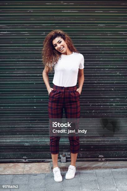 Niña Árabe Sonriente En Ropa Casual En La Calle Foto de stock y más banco de imágenes de Mujeres - Mujeres, Una sola mujer, Camiseta