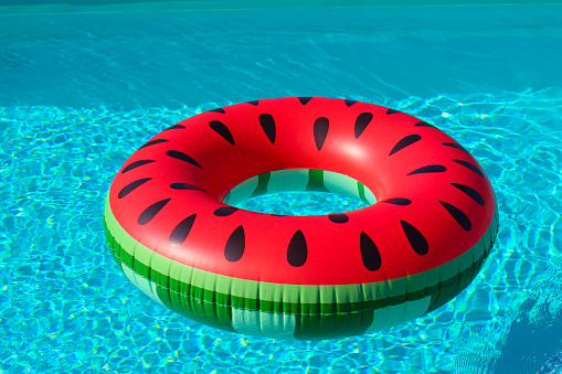 Summer season. inflatable ring  watermelon in the blue water of the pool. Hello summer