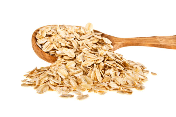 istock Oatmeal groats in wooden spoon on a white background 917163152