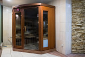a small wooden infrarered sauna booth in a spa
