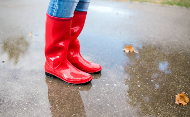 istock Rubber boots are jumping into a big puddle with splash. 917169738