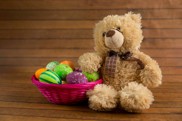 istock Easter color painted eggs in basket and teddy bear 917169994