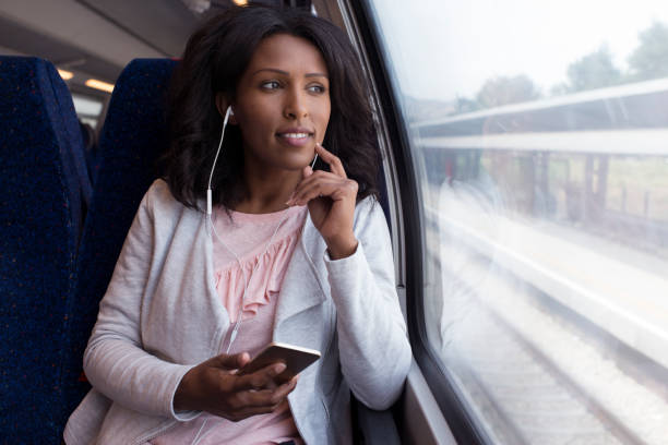 mujer escuchar la música en el tren. - bus coach bus travel red fotografías e imágenes de stock