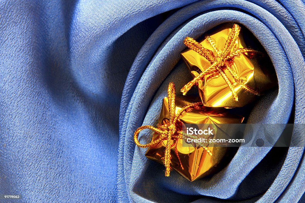 Cajas de oro sobre fondo de seda azul - Foto de stock de Amarillo - Color libre de derechos