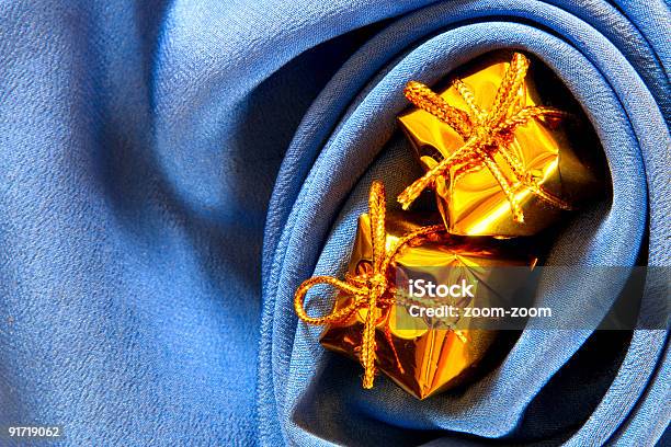 Cajas De Oro Sobre Fondo De Seda Azul Foto de stock y más banco de imágenes de Amarillo - Color - Amarillo - Color, Arrugados, Azul