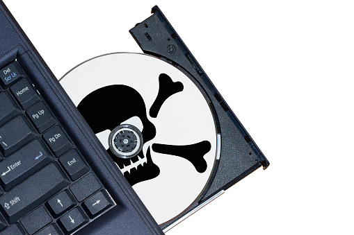 Pirate cd in the cd-rom of the laptop (piracy concept)