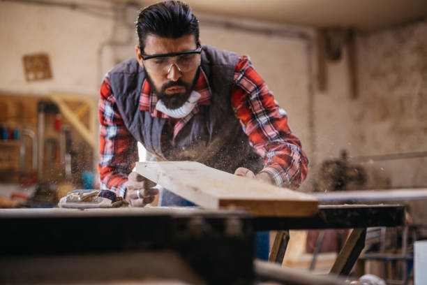 istock Carpenter blowing dust from wooden plank 917195288