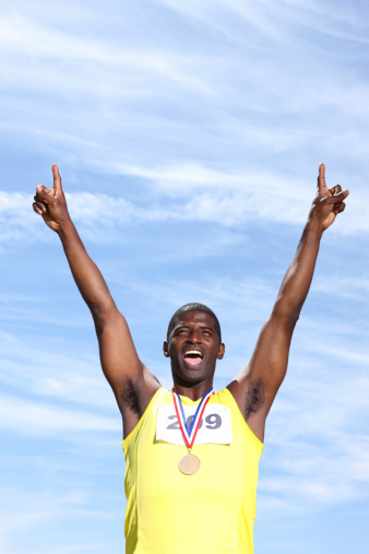 African American athlete with medal celebrating
