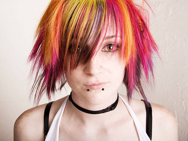 Young girl with lip piercings and brightly colored hair stock photo