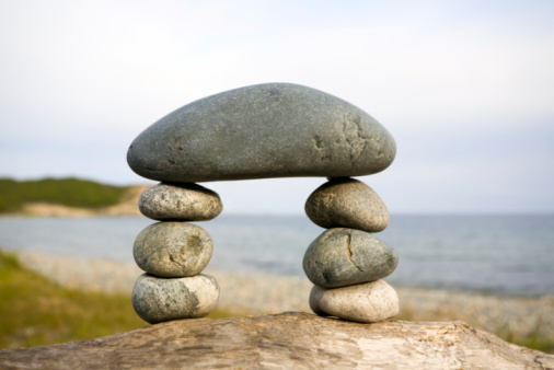 Balanced stones on a pebble beach during sunset