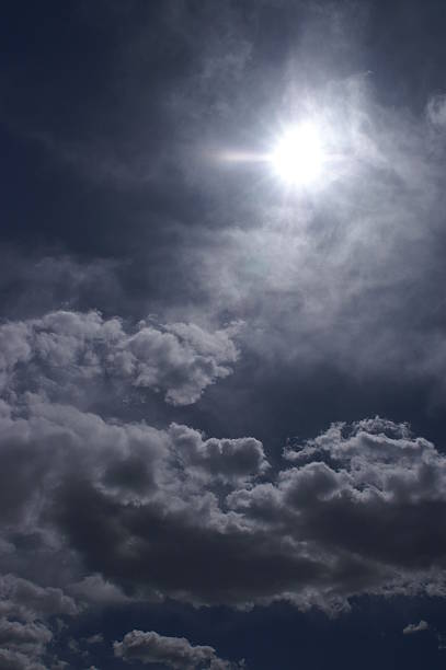 Sun through blue clouds stock photo