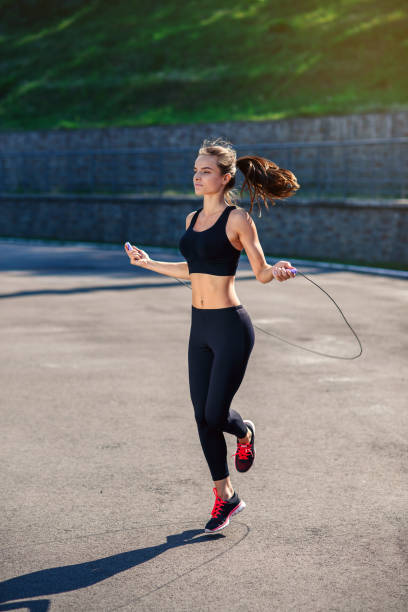 istock Athlete woman jumping with skipping rope at stadium. 917199990