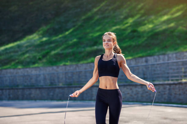istock Athlete woman jumping with skipping rope at stadium. 917199996