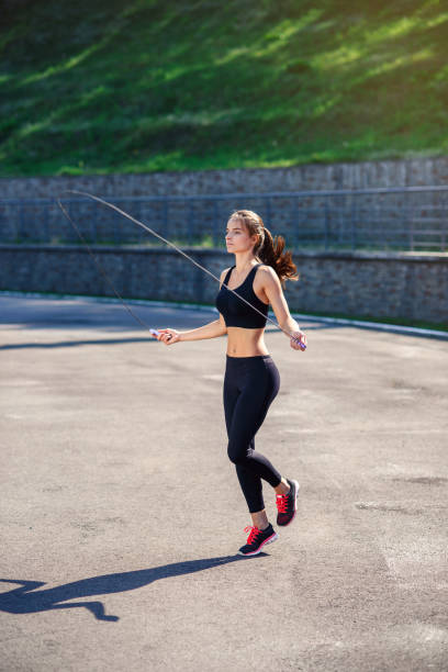 istock Athlete woman jumping with skipping rope at stadium. 917200000